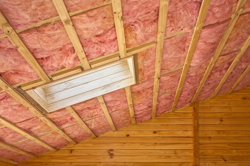pink insulation on underside of sloped roof with skylight