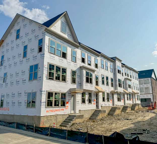 A row of houses under construction with "No Trespassing" signs.