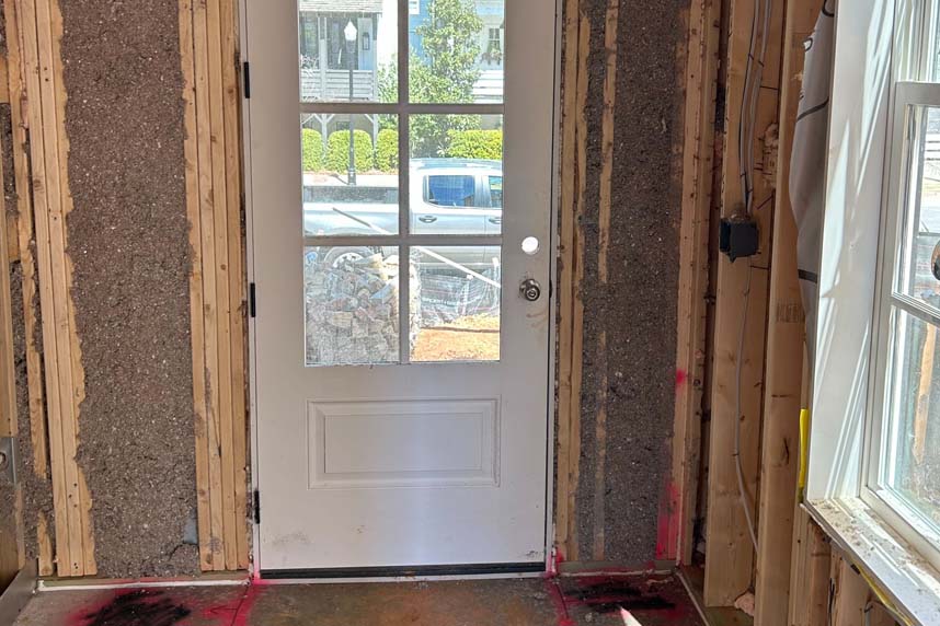 Cellulose insulation packed around a framed exterior door in residential construction project