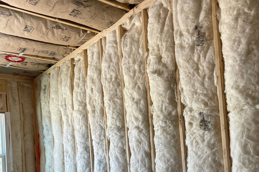 Window wall with partially installed batt insulation and visible framing