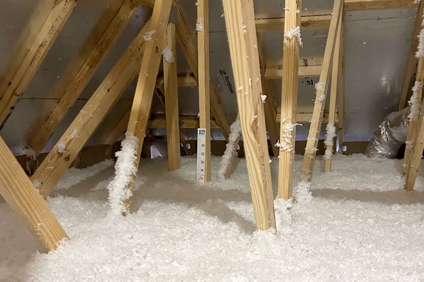 Attic space with loose-fill cellulose or fiberglass insulation blown in between roof trusses